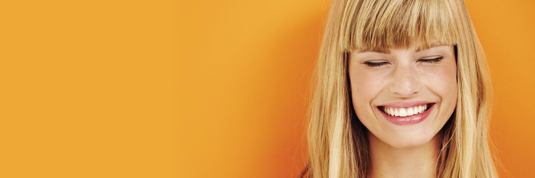 Woman smiling against an orange wall near Chico CA